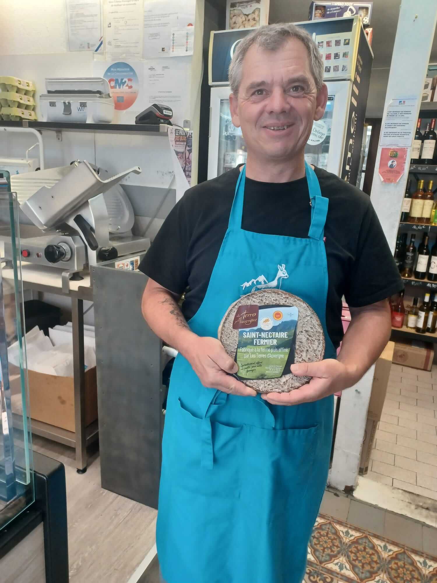 David, franchisé Laiterie Gilbert à Nantes, présente un Saint-Nectaire fermier dans sa fromagerie